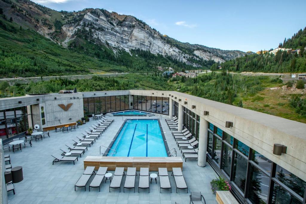 a hotel with a pool and chairs and a mountain at Cliff Lodge and Spa in Snowbird Lodge