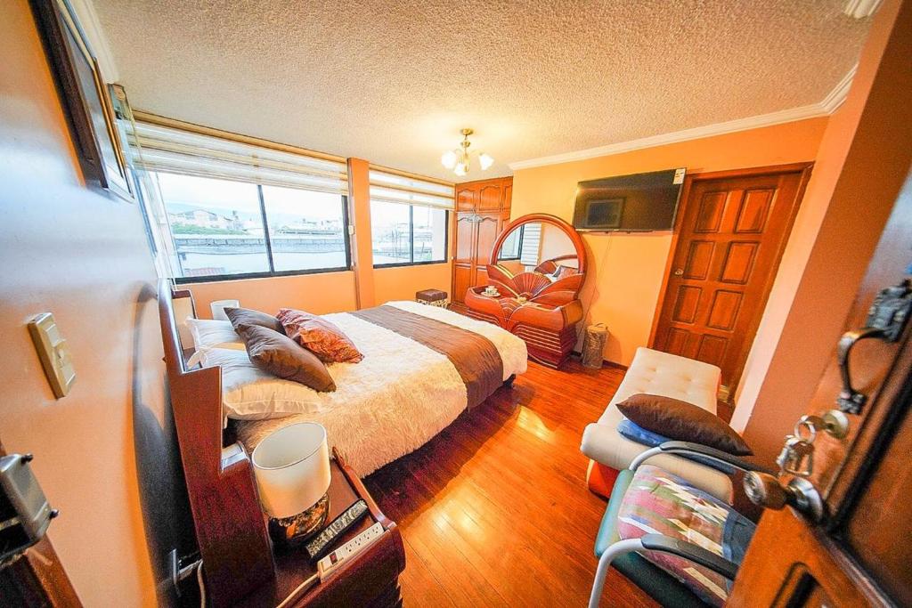 a bedroom with a bed and a chair in it at Casa de Mármol in Riobamba