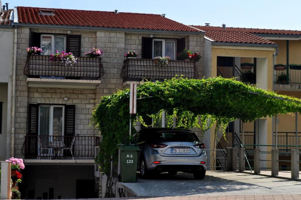 a small car parked in front of a house at Apartments and rooms Ljuba - 130 meter from sea in Makarska