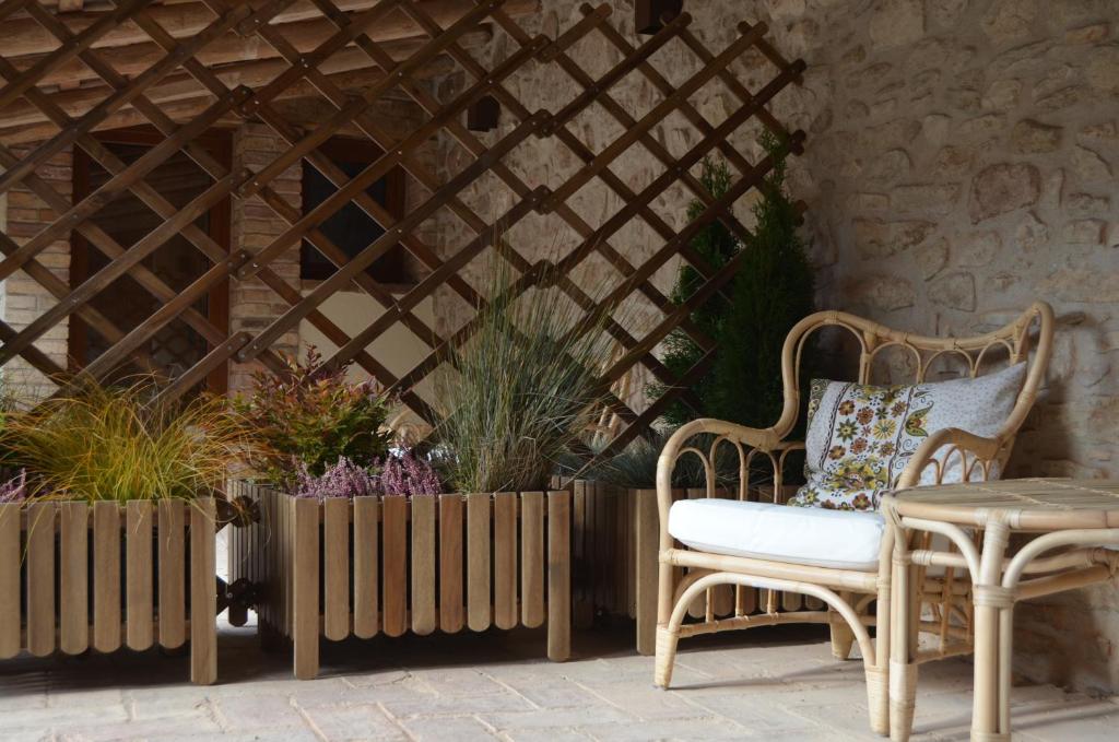 un patio con 2 sillas, una mesa y algunas plantas en Cal Puó Turismo Rural, en Collsuspina