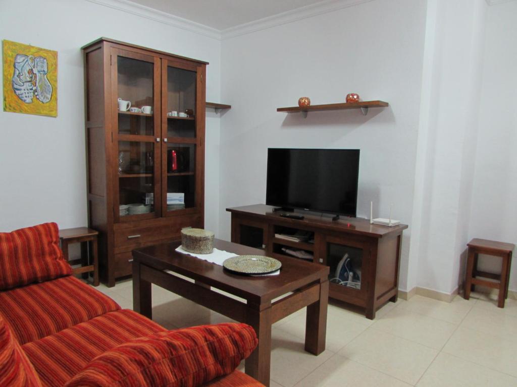 a living room with a couch and a tv at Garrucha Apartment in Garrucha