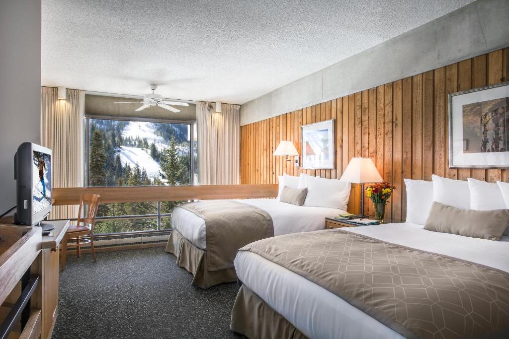 a hotel room with two beds and a television at The Lodge at Snowbird in Alta