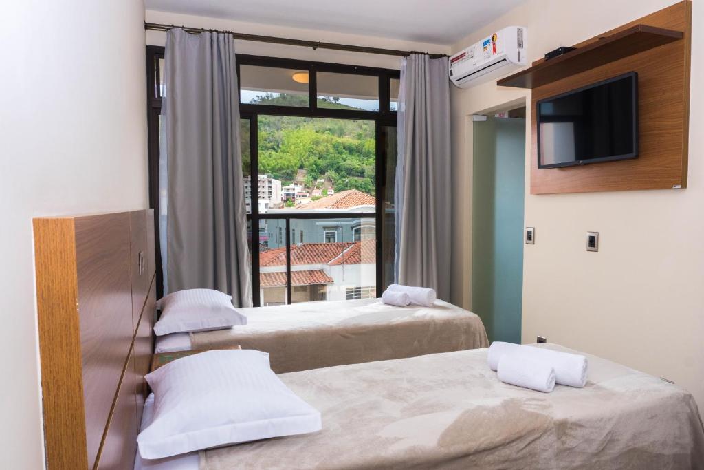 a room with two beds and a tv and a window at Hotel Casa Alfredo in Socorro