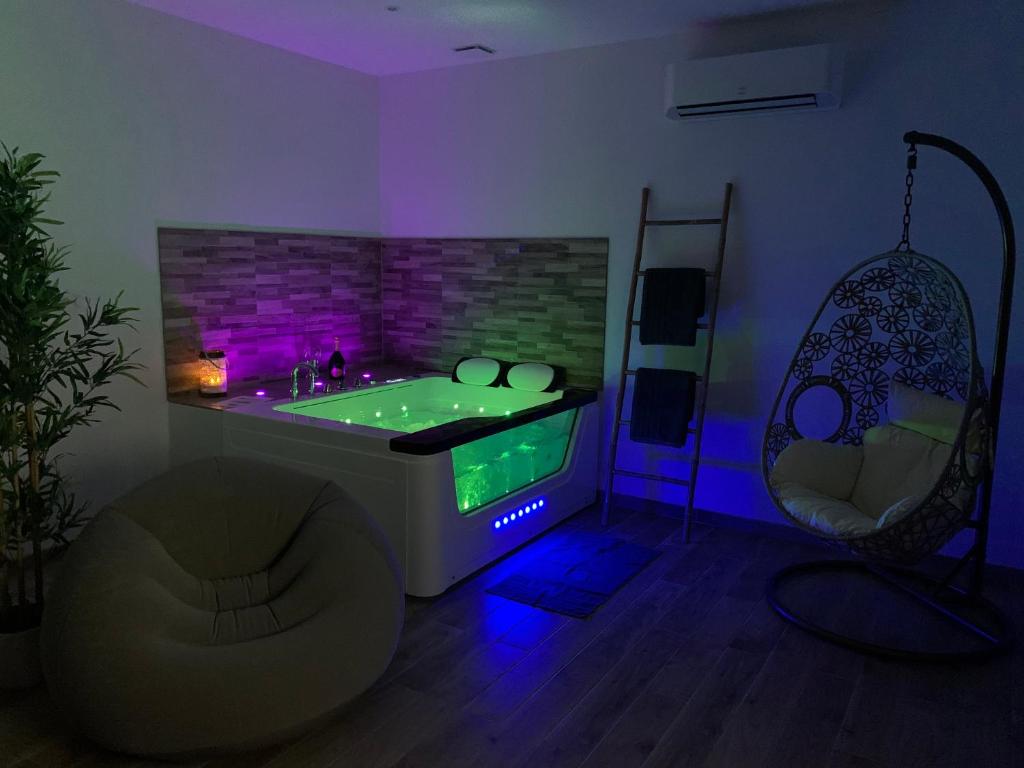 Appartement Cosy Jacuzzy Luxe Gare de Toulon في تولون: غرفة مع حوض جاكوزي مع أضواء أرجوانية