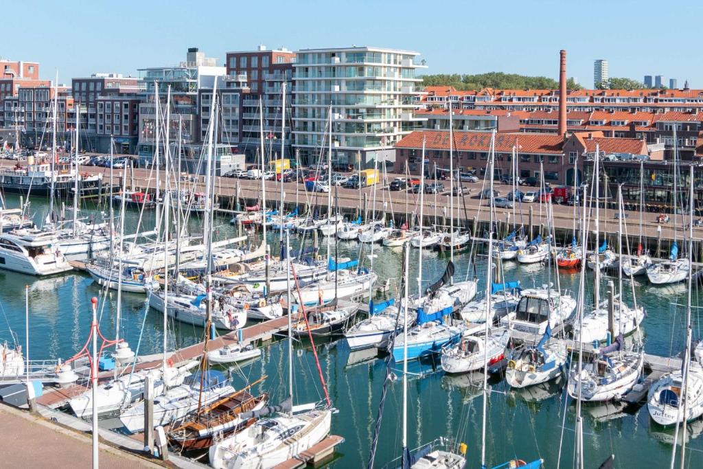 a bunch of boats docked in a marina with buildings at Scheveningen Diamond View Beach and Harbour in Scheveningen