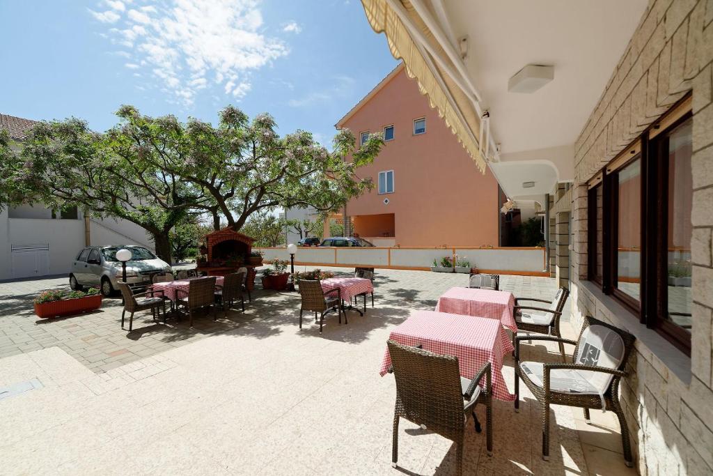 a patio with tables and chairs and a fire place at Apartments Mar - 150 m from sea in Rab
