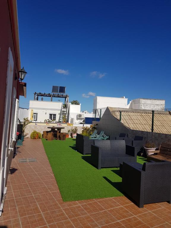 een patio met zwart meubilair en groen gras bij Hotel Bela Vista in Olhão