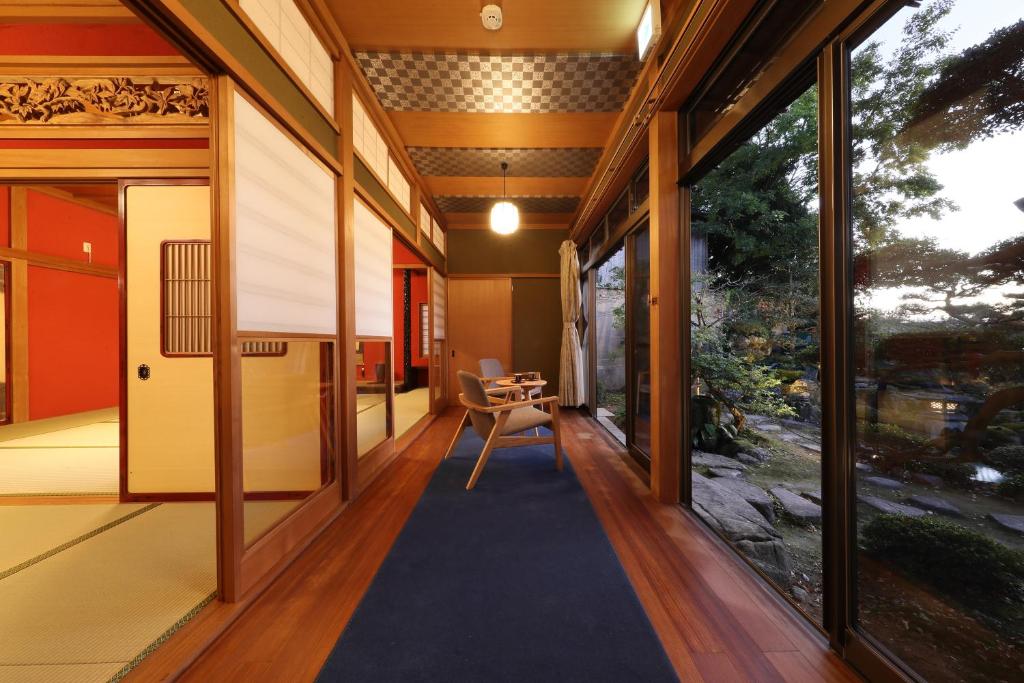 和美再美 石動 柏屋 Wabisabi Isurugi Kashiwaya في Oyabe: مدخل منزل مع سجادة زرقاء