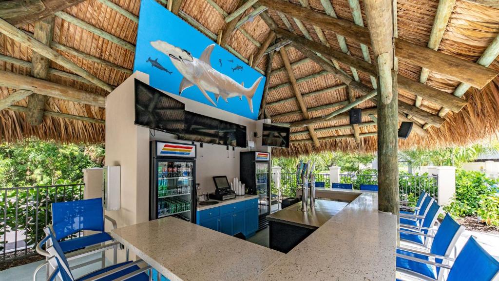 an outdoor kitchen with blue chairs and a table at Staybridge Suites - Naples - Marco Island by IHG in Naples