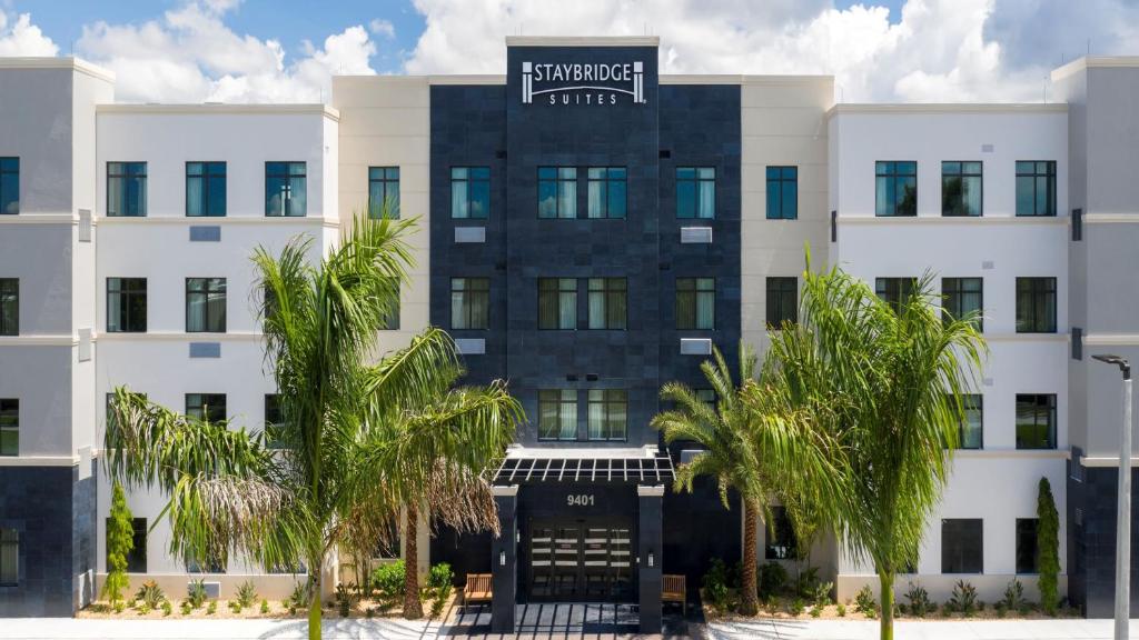 a building with palm trees in front of it at Staybridge Suites - Naples - Marco Island by IHG in Naples