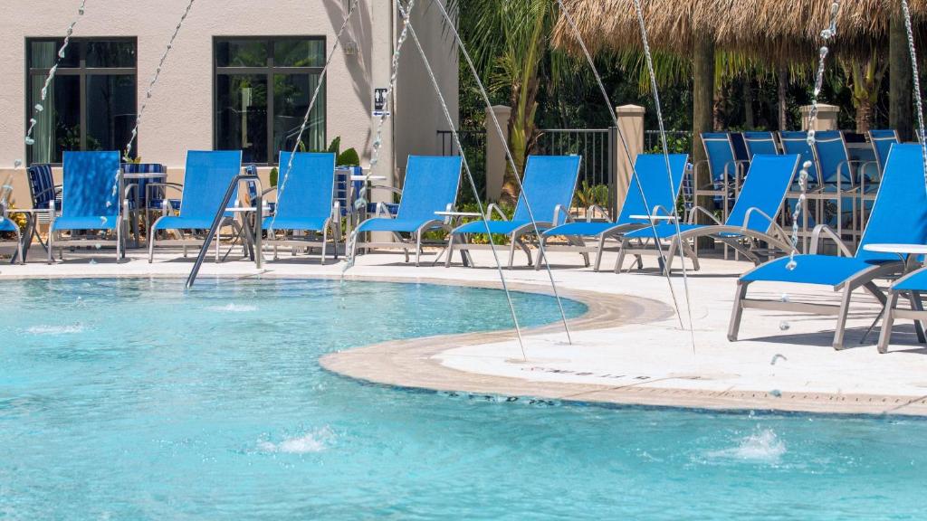 a group of blue chairs and tables in a pool at Staybridge Suites - Naples - Marco Island by IHG in Naples