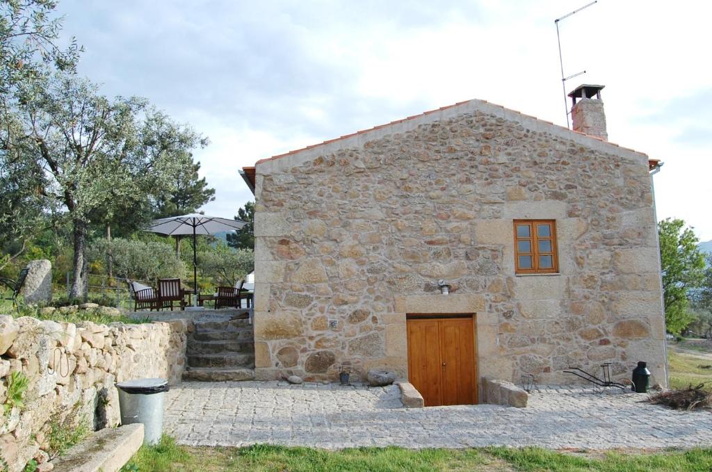 un pequeño edificio de piedra con puerta de madera en Casa da Carriça - Serra da Estrela en Guarda