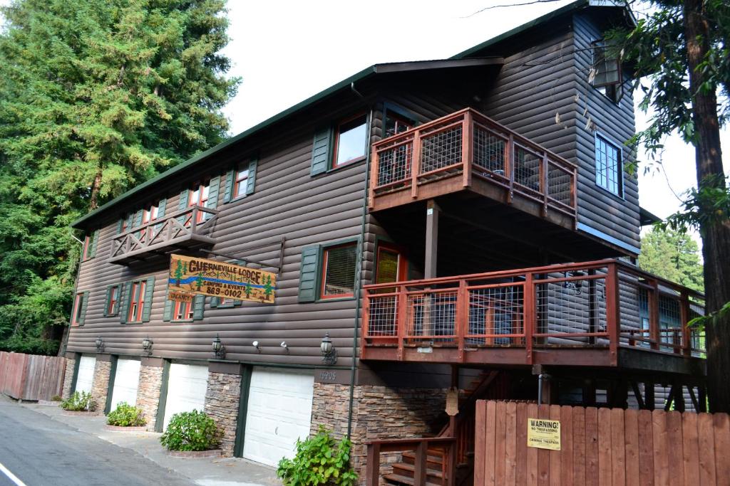 Guerneville Lodge في جيرنفيل: منزل خشبي كبير مع شرفة على جانبه