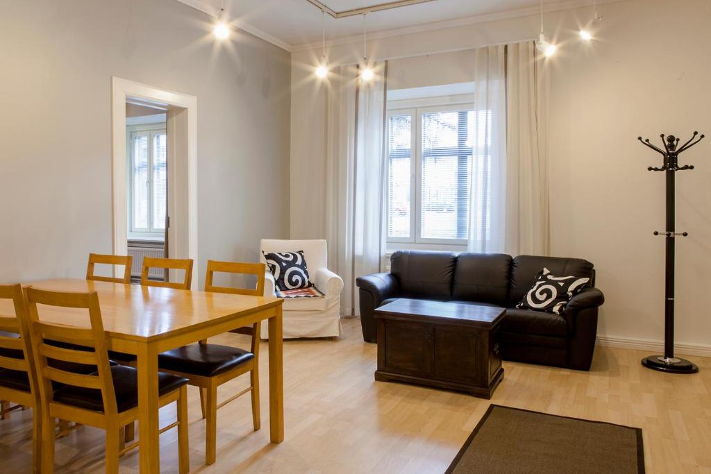 - un salon avec une table et un canapé dans l'établissement Hotelli Ville Apartment, à Tampere