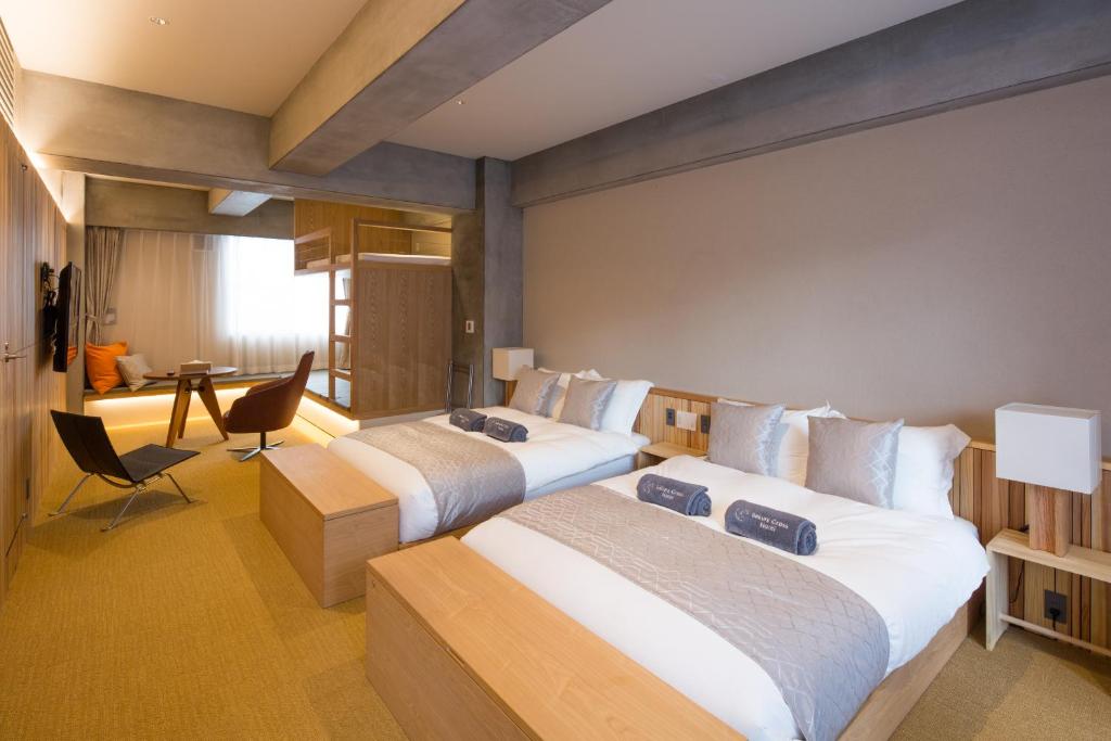 a hotel room with two beds and a desk at Sakura Cross Hotel Tokyo Kayabacho in Tokyo