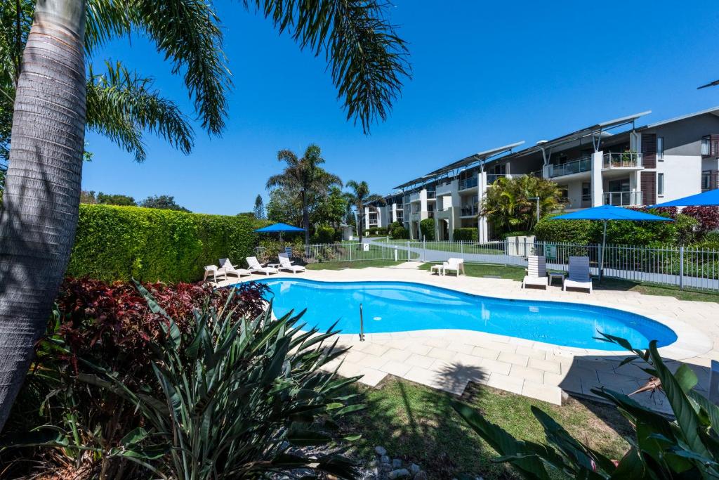 a beach with a pool and a pool table at Pacific Marina Apartments in Coffs Harbour