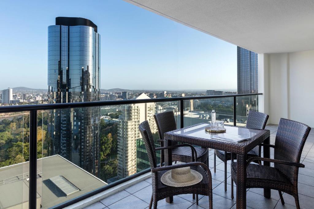 
a dining room with a balcony overlooking a city at iStay River City Brisbane in Brisbane
