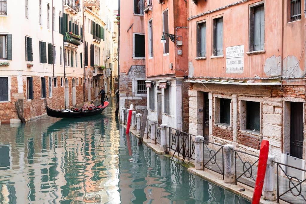 a gondola in a canal between two buildings at San Marco 4893 in Venice