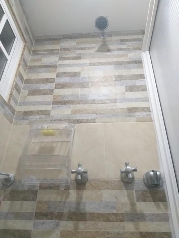 uma casa de banho com um chuveiro e piso em azulejo em Holiday Loft Suite Apartamento em San Andrés