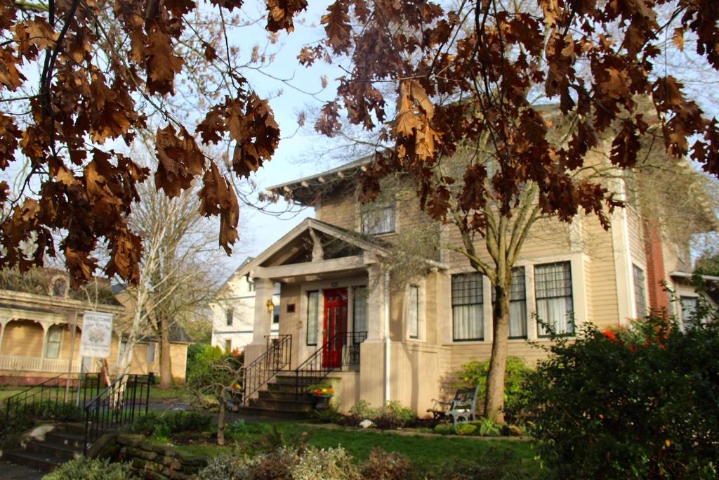 a large house with a red door and trees at Briar Rose Inn Vancouver WA USA in Vancouver