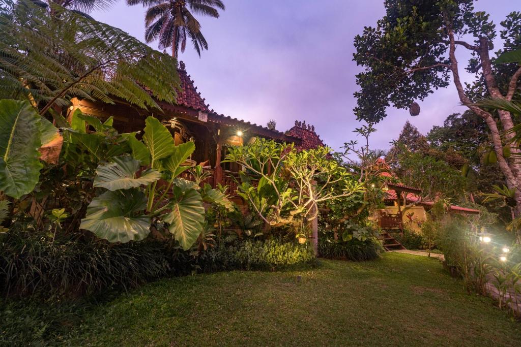 a house with a garden at night at Be Bali Hut Farm Stay in Ubud