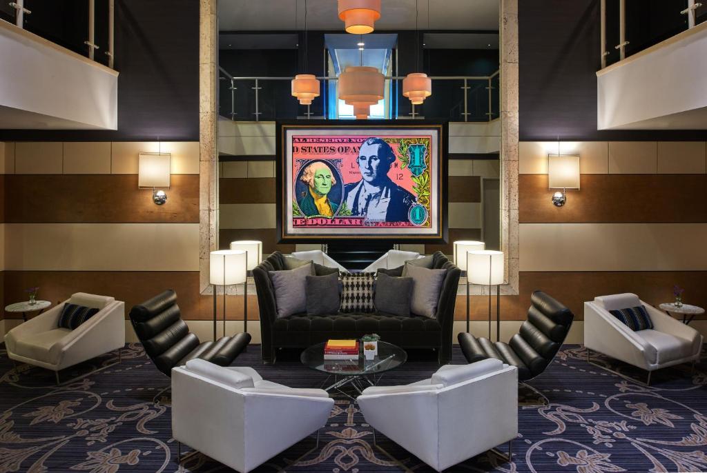 a lobby with a couch and chairs and a tv at Kimpton George Hotel, an IHG Hotel in Washington, D.C.