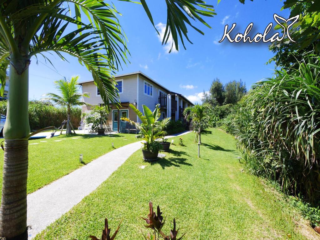 a house with a palm tree and a sidewalk at Private Vacation Villa Kohola in Motobu