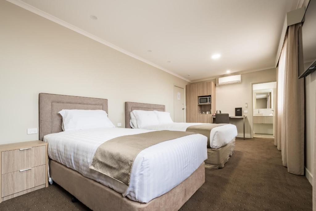 a hotel room with a bed and a desk at The Lighthouse Hotel in Ulverstone