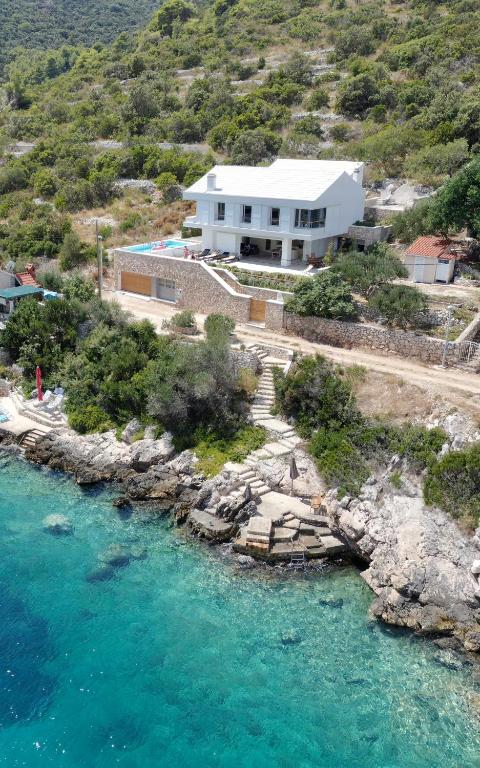 a house on a hill next to a body of water at Villa Talia in Donje Selo na Šolti