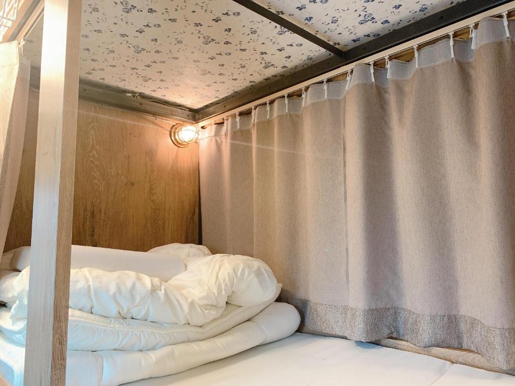 a bed in a room with a curtain at Good Diner Inn Copain in Tokyo