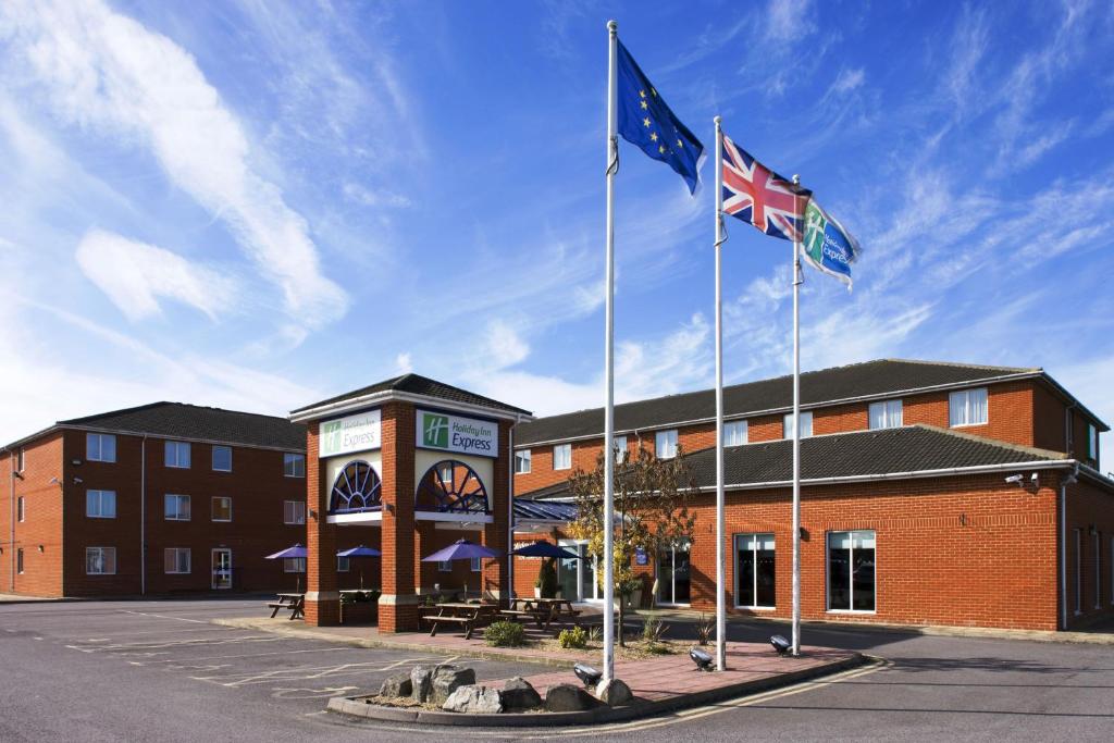 duas bandeiras a voar em frente a um edifício em Holiday Inn Express Southampton West, an IHG Hotel em Southampton