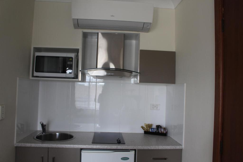 a kitchen with a sink and a microwave at Centrepoint Motel in Dubbo