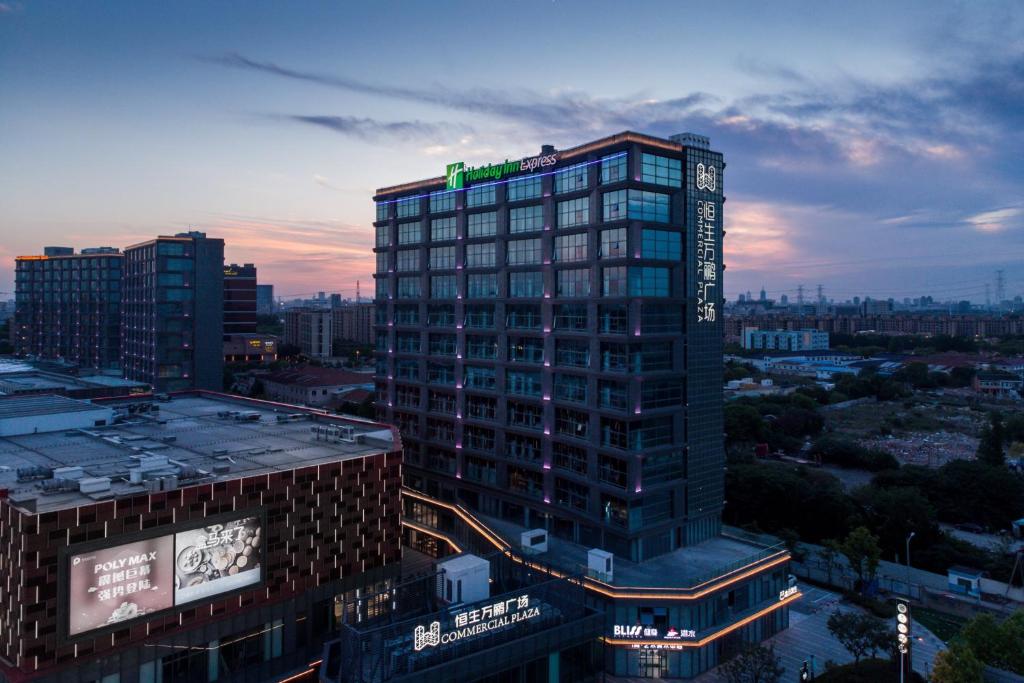 上海市にあるHoliday Inn Express Shanghai Tangzhen, an IHG Hotelの看板が上がる高層ビル