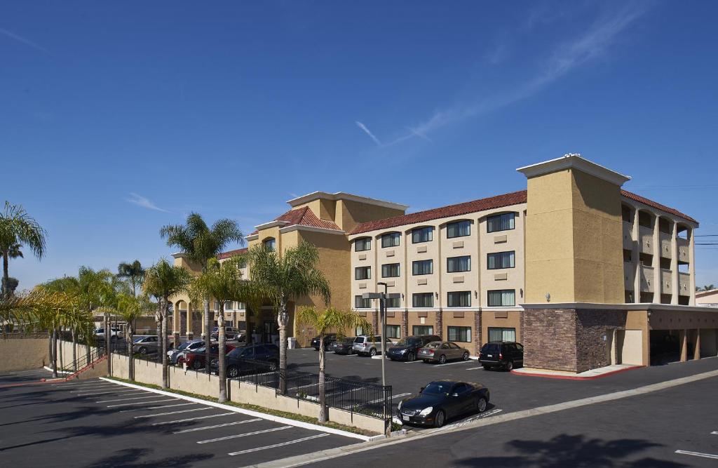 ein großes Gebäude mit Autos auf einem Parkplatz in der Unterkunft Holiday Inn Express San Diego South - National City, an IHG Hotel in National City