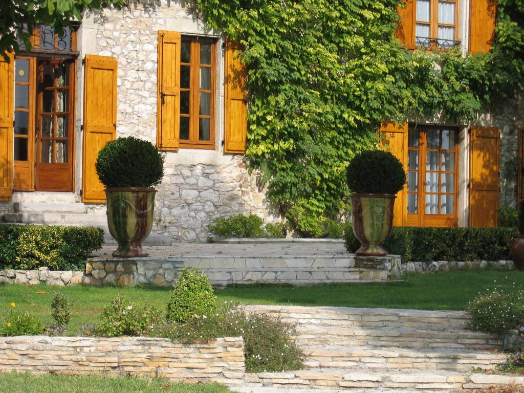 a house with two vases in front of it at La Frandomière in Saint-Martin-de-Londres