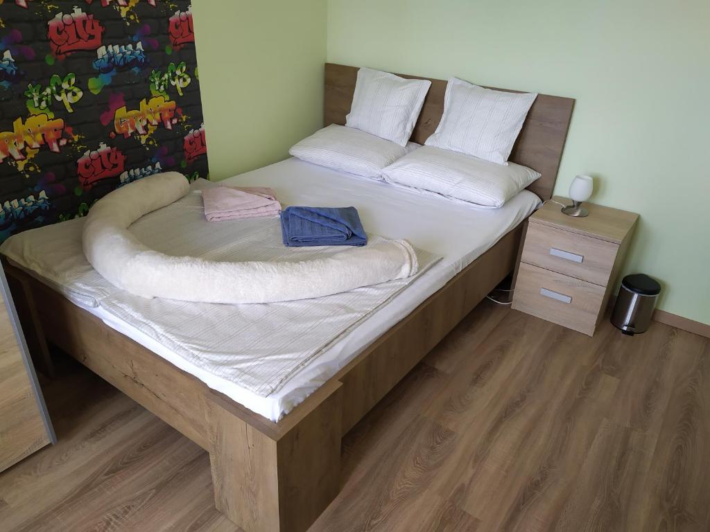 a bedroom with a large bed with a wooden floor at Legyél a vendégünk :) in Debrecen