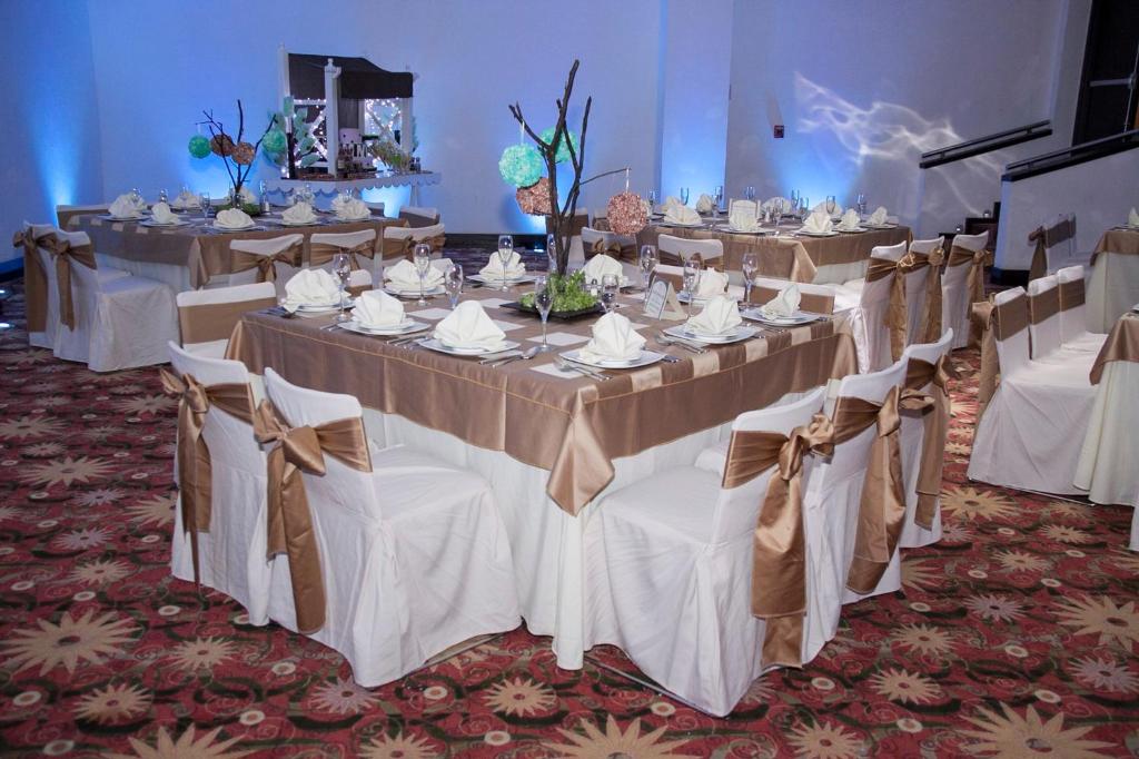 Holiday Inn Tuxtla Gutierrez, an IHG Hotel في توكستلا غوتيريز: مجموعة طاولات مأدبة مع قماش الطاولة البيضاء