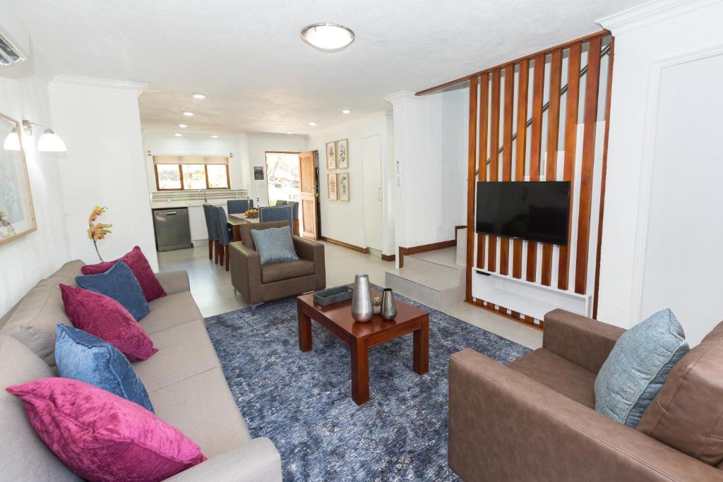 a living room with a couch and a television at Kruger Park Lodge Unit No. 610B in Hazyview