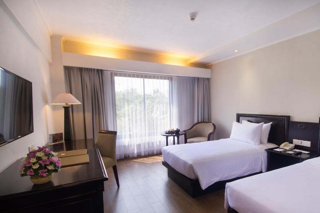 Postel nebo postele na pokoji v ubytování Hotel Santika Cirebon
