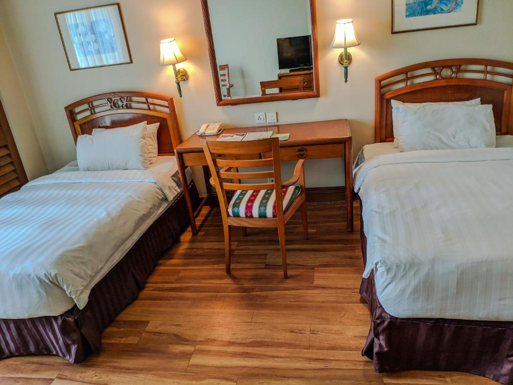 Postel nebo postele na pokoji v ubytování Sabah Oriental Hotel