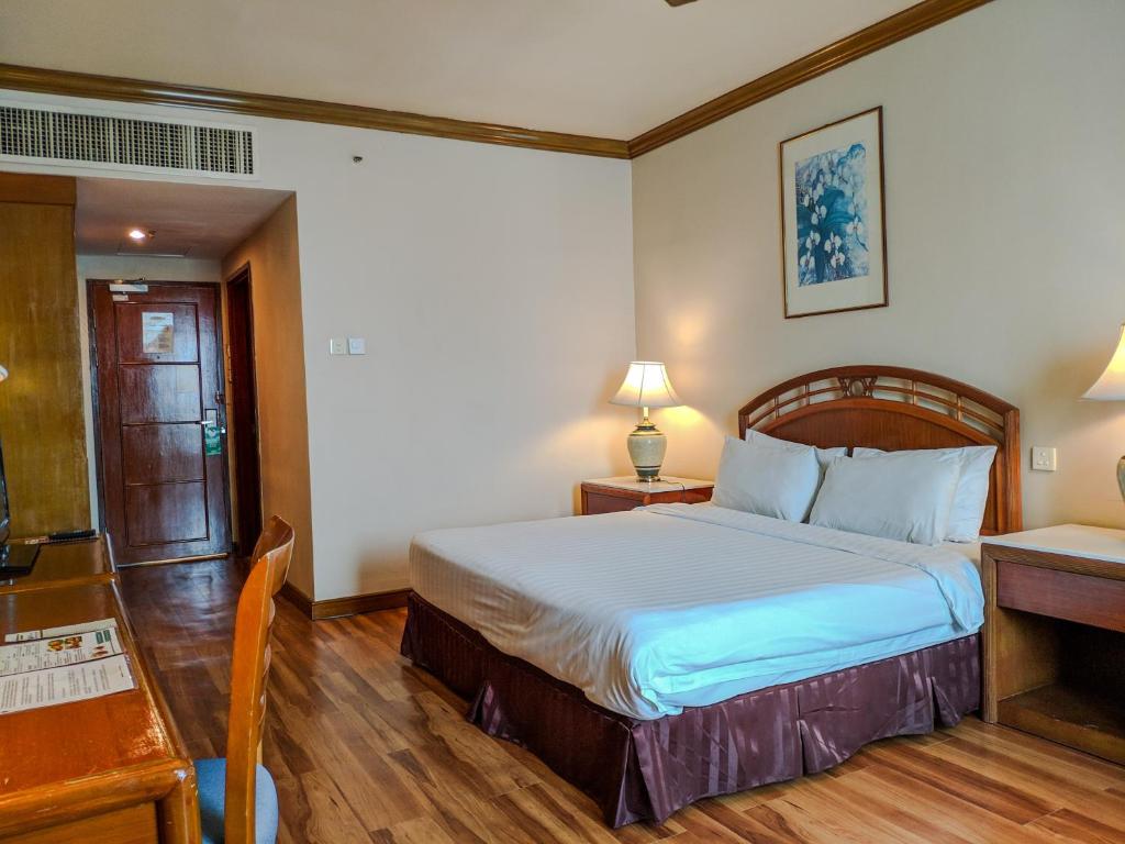 Postel nebo postele na pokoji v ubytování Sabah Oriental Hotel