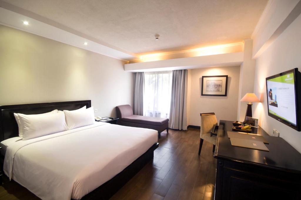 Postel nebo postele na pokoji v ubytování Hotel Santika Cirebon