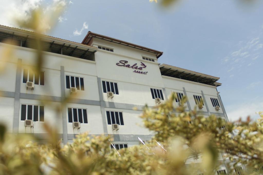 - un grand bâtiment blanc avec un panneau dans l'établissement Salsa Resort Langkawi By Casa Loma, à Pantai Cenang