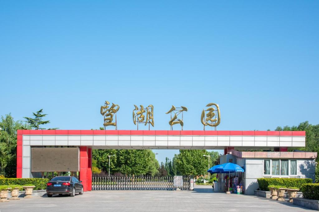 ein Auto, das unter einem Schild auf einem Parkplatz geparkt ist in der Unterkunft Holiday Inn Express Beijing Huacai, an IHG Hotel in Peking