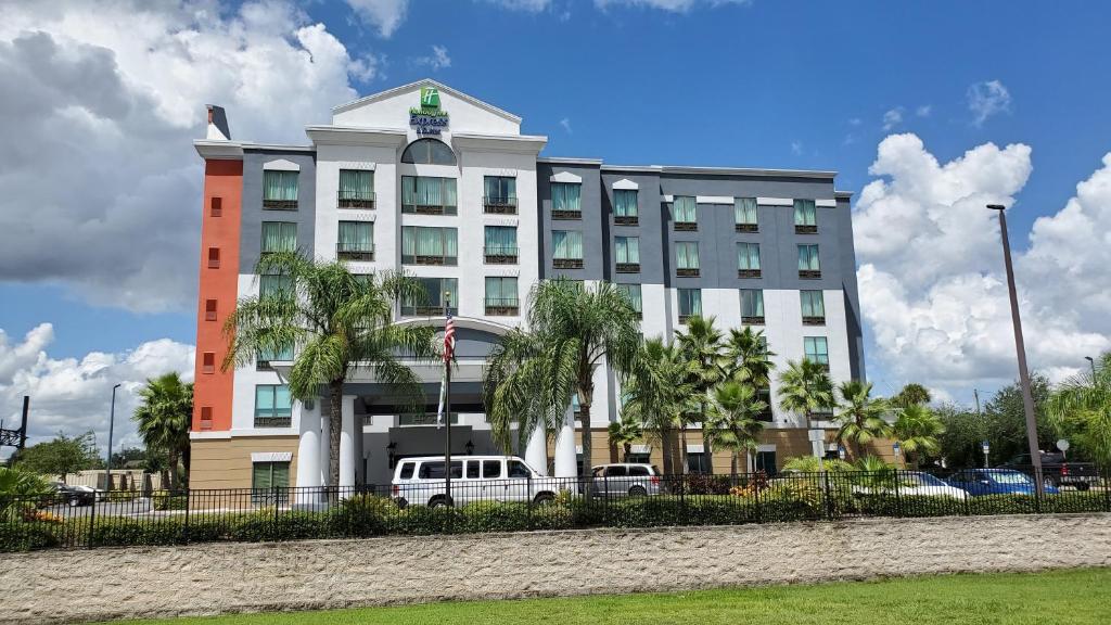 um edifício branco com um carro estacionado em frente em Holiday Inn Express-International Drive, an IHG Hotel em Orlando