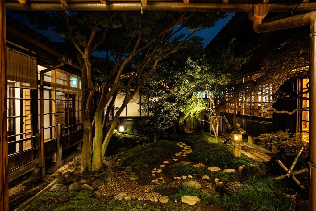 un jardín por la noche con un árbol y luces en 宿坊 観音院 Temple Hotel Kannonin, en Kiryu