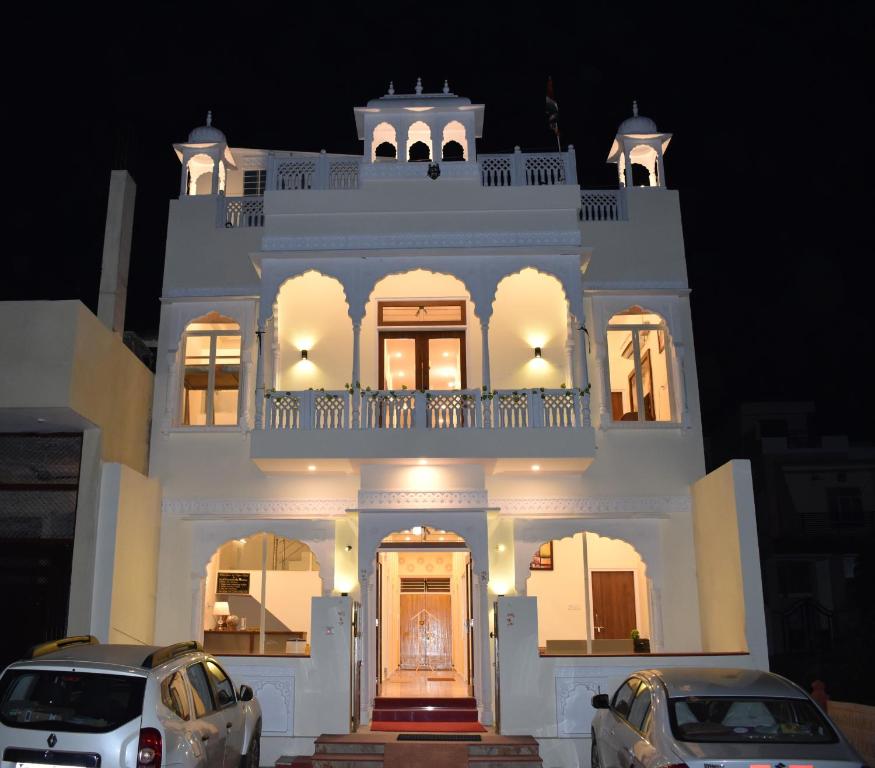 a large white building with cars parked in front of it at Ranthambore MAHÀL in Sawāi Mādhopur