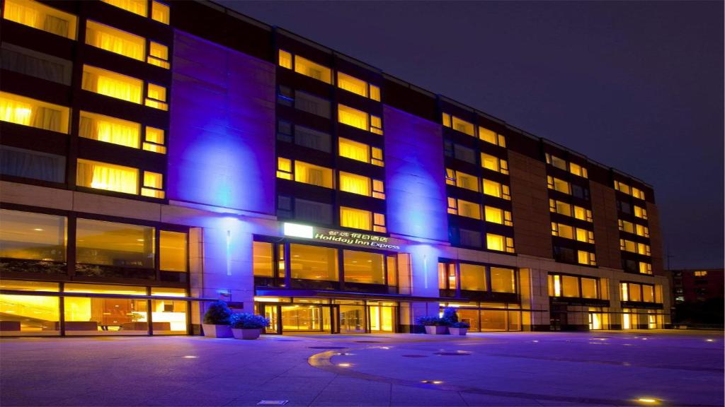 a large building with blue lights on it at night at Holiday Inn Express Beijing Temple of Heaven, an IHG Hotel in Beijing