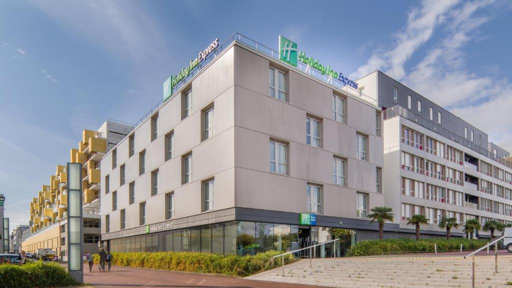 Un bâtiment blanc avec un panneau en haut dans l'établissement Holiday Inn Express Saint-Nazaire, an IHG Hotel, à Saint-Nazaire