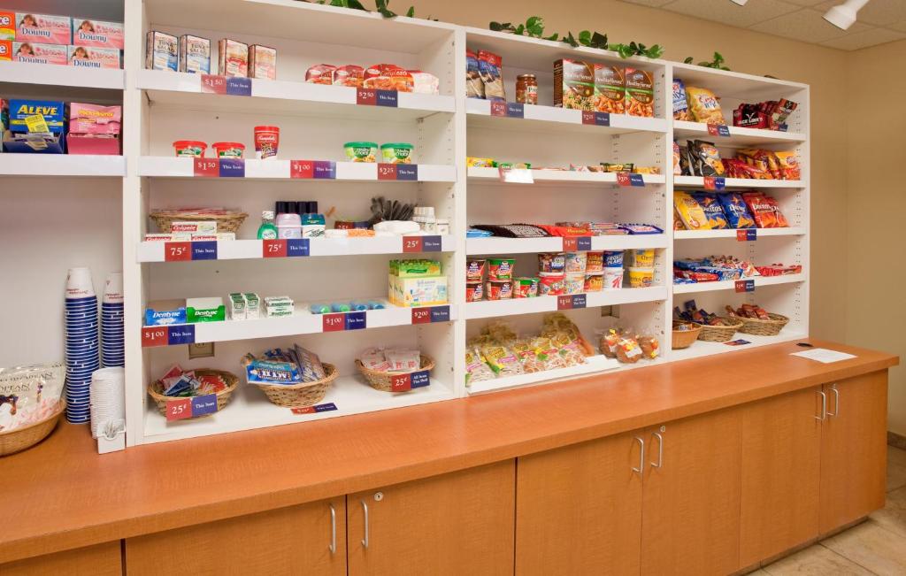 a food pantry with white shelves with food items at Candlewood Suites Olathe, an IHG Hotel in Olathe